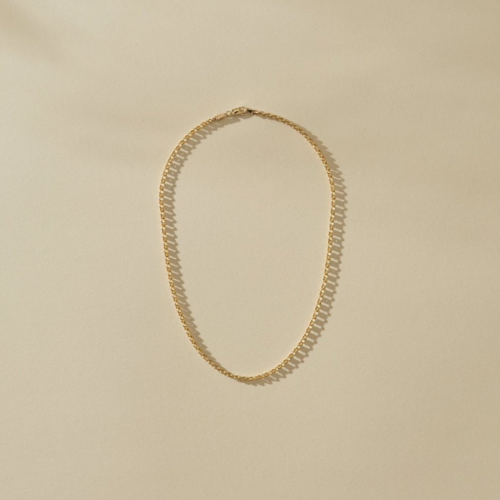 Gold necklace on a beige background